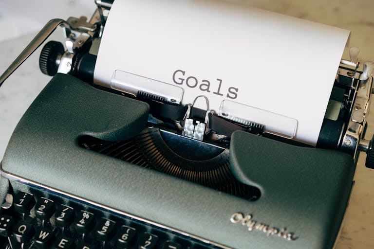 Close-up of a vintage typewriter with the word 'Goals' on paper, symbolizing planning.